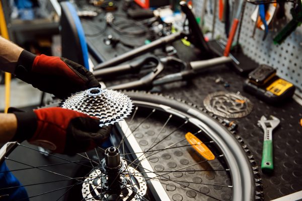 bicycle-repair-in-workshop-man-installs-cassette-VVSSLH6